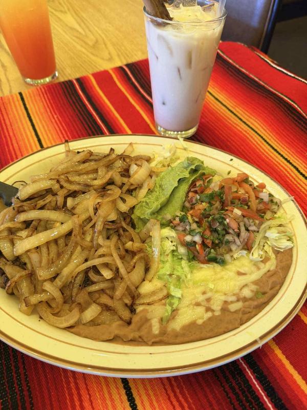 Steak and onions plate with beans and guacamole